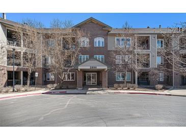 Attractive brick condo building with covered entrance and well-maintained landscaping and parking at 2896 W Riverwalk Cir # A214, Littleton, CO 80123