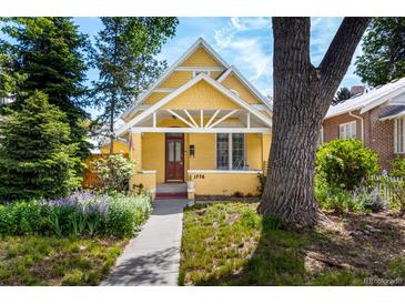 Charming yellow home with a well-manicured front yard and walkway leading to the entrance at 1776 S Logan St, Denver, CO 80210