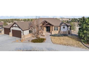 Beautiful single-Gathering home featuring stone accents, a three-car garage, and mature landscaping at 46692 Silver Fir St, Parker, CO 80138