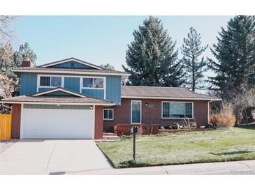 Charming two-story home featuring brick and blue siding with a well-manicured front lawn and driveway at 5404 W Rowland Pl, Littleton, CO 80128