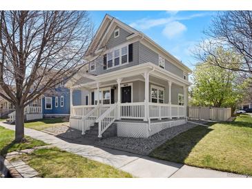 Charming two-story home boasts a welcoming front porch and beautifully landscaped front yard at 9472 E 109Th Pl, Commerce City, CO 80640