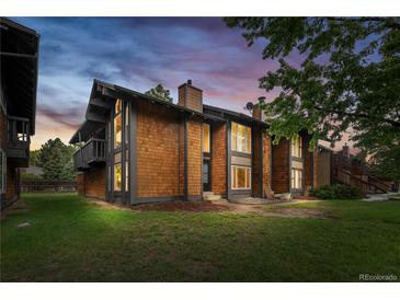 Stunning exterior view of a shingled townhome with a charming balcony and lush green lawn at 1347 S Crystal Way, Aurora, CO 80012