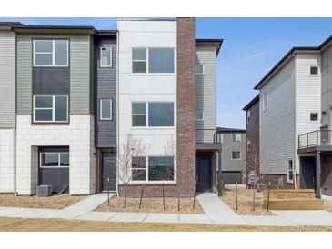 Modern townhome featuring mixed siding, brick accents, and low-maintenance landscaping at 453 Interlocken Blvd # 101, Broomfield, CO 80021