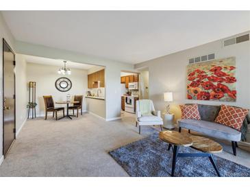 Open-concept living room with a dining area and access to the kitchen, creating a seamless flow for modern living at 519 Wright St # 106, Lakewood, CO 80228