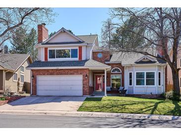 Charming two-story home featuring a brick facade, attached two car garage, and well-maintained front yard at 1206 E Phillips Pl, Littleton, CO 80122