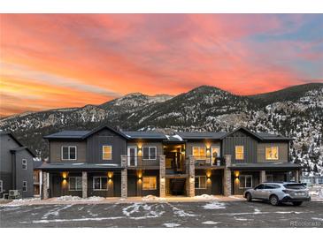 Modern townhome exterior featuring stone accents, private balconies, and stunning mountain views at sunset at 2152 Bighorn Rd # 203, Georgetown, CO 80444