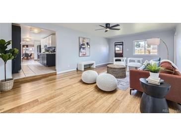Bright living room with modern decor, wood floors, and an open layout leading to the kitchen at 1280 S Quitman St, Denver, CO 80219