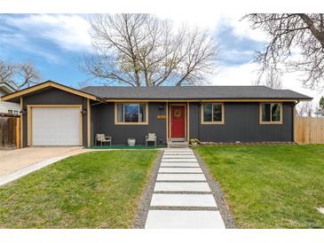 Charming single-story home with a red door, landscaped lawn, and inviting walkway at 13020 Julian Ct, Broomfield, CO 80020