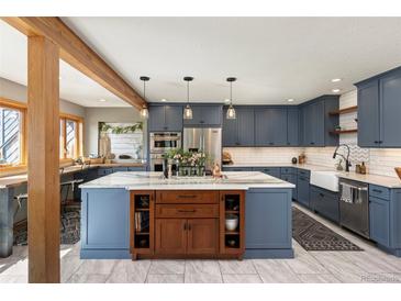 Open kitchen featuring blue cabinets, a large center island, and stainless steel appliances at 4948 Cameyo Rd, Indian Hills, CO 80454