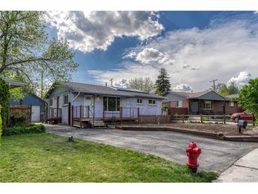 Charming single-story home featuring a well-maintained lawn and a welcoming front porch with solar panels above at 7541 Julian St, Westminster, CO 80030