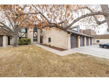 Inviting exterior of brick home with a three-car garage and mature landscaping at 7250 Eastmoor Dr # 105, Denver, CO 80237