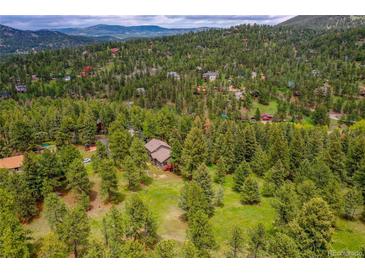 Expansive aerial view of home nestled amongst many trees in scenic mountain community at 28065 Camel Heights Cir, Evergreen, CO 80439