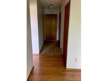 View of the front door with tile, and hardwood floors in the hallway at 9335 E Center Ave # 7C, Denver, CO 80247