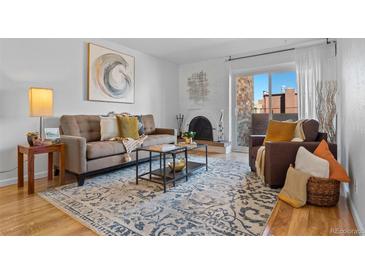 Cozy living room with fireplace, stylish rug, and comfortable seating area at 252 N Pennsylvania St # 305, Denver, CO 80203