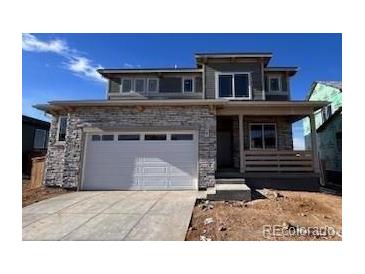 Two-story house with stone accents and a two-car garage at 393 Grey Rock St, Brighton, CO 80601