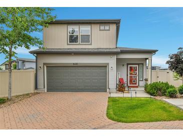 Charming two-story home features a gray exterior, two-car garage and a red front door at 5131 Andes St, Denver, CO 80249