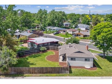 Charming home featuring a spacious backyard, mature trees, and a fenced-in yard at 1420 S Leyden St, Denver, CO 80224