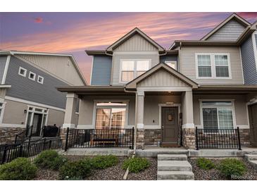 Charming townhouse featuring stone accents, covered porch, and landscaped front yard at 20000 E 40Th Ave # 4, Denver, CO 80249