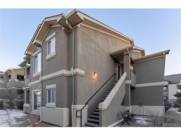 Exterior view of a two-story townhome with stairs and a small patio area at 4538 Copeland Loop # 202, Highlands Ranch, CO 80126