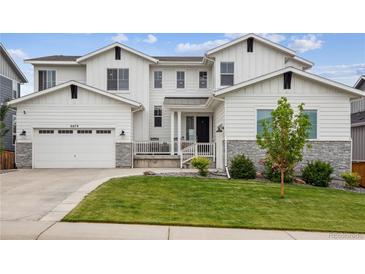 Charming two-story home with a well-manicured lawn and a two-car garage at 6679 Kenzie Cir, Castle Pines, CO 80108