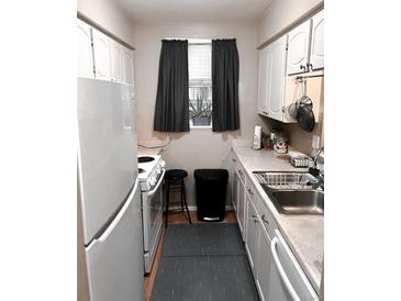 Functional kitchen features white appliances, ample cabinet space, and a bright window at 3626 S Granby Way # L03, Aurora, CO 80014