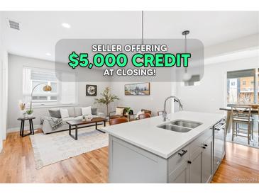 Bright and airy living room showcasing modern gray tones, beautiful hardwood floors, and ample natural light at 1733 Irving St # 101, Denver, CO 80204