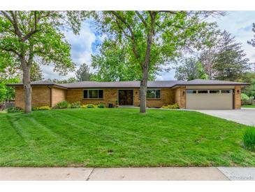 Charming brick home featuring a lush green lawn, mature trees, and a spacious two-car garage at 5890 W Quarles Dr, Littleton, CO 80128