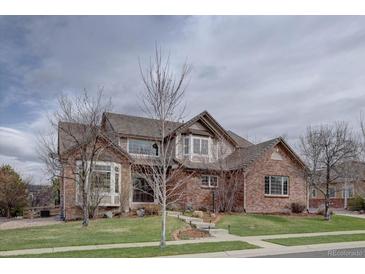 Charming two-story brick home featuring a manicured lawn, bay windows, and a beautifully tiled roof at 15857 E Aberdeen Ave, Centennial, CO 80016