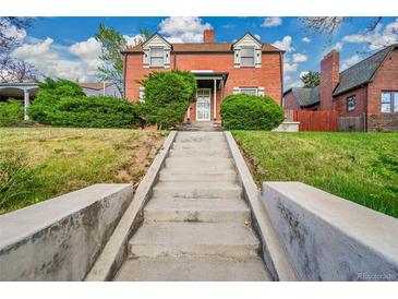 Charming brick home featuring lush landscaping and a welcoming front entrance with concrete stairs at 3070 Colorado Blvd, Denver, CO 80207