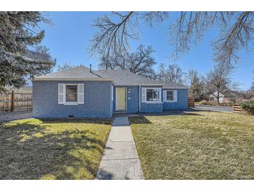 Charming one-story blue brick home with a well-maintained front lawn and a welcoming yellow front door at 7100 E 5Th Ave, Denver, CO 80220
