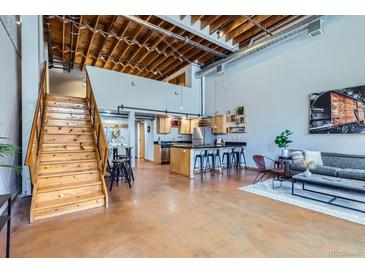 Inviting living room with open floor plan, staircase, modern kitchen, and abundant natural light at 2715 Blake St # 2, Denver, CO 80205