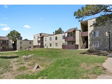 Multi-Gathering residential building with individual balconies and grassy lawn in a tranquil community setting at 9725 E Harvard Ave # 305, Denver, CO 80231
