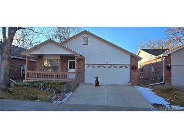 Ranch style home with attached garage and landscaped yard at 6567 Pierson St, Arvada, CO 80004