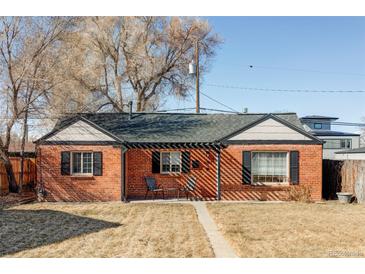 Charming brick home featuring black shutters, a covered front porch, and a well-manicured front yard at 3641 N Cook St, Denver, CO 80205