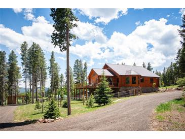 Beautiful log home nestled in the trees with a large deck, perfect for enjoying the outdoors at 11652 Camp Eden Rd, Golden, CO 80403