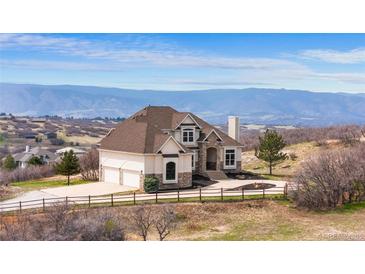 Stately stucco home featuring grand architecture and breathtaking mountain views, set amidst a serene landscape at 3074 Castle Butte Dr, Castle Rock, CO 80109