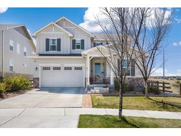 Charming two-story home boasts a two-car garage, stone accents, and a well-manicured lawn in a desirable neighborhood at 24222 E Canyon Pl, Aurora, CO 80016