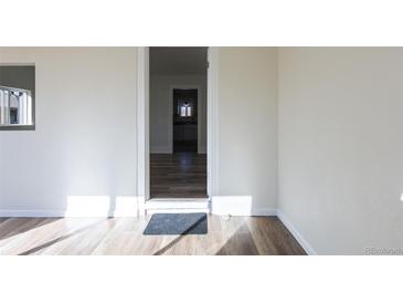 Bright living room with wood flooring leading to kitchen area at 1435 Jay St, Lakewood, CO 80214