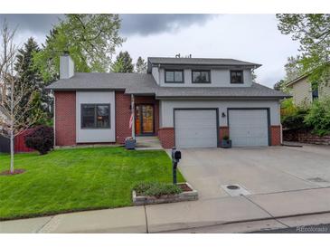 Charming two-story home with a well-manicured lawn and a two-car garage at 66 Yank Way, Lakewood, CO 80228