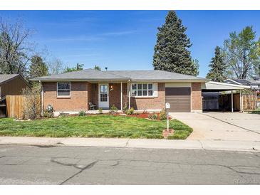 Charming brick home with a well-maintained lawn, attached garage and a covered carport at 5225 Beech St, Arvada, CO 80002
