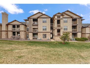 View of condo building with stucco and stone exterior and multiple decks overlooking lawn at 7483 S Quail Cir # 626, Littleton, CO 80127