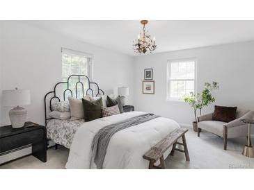 Bright bedroom featuring a decorative chandelier, cozy seating, and large windows for ample natural light at 6982 Estes Dr, Arvada, CO 80004