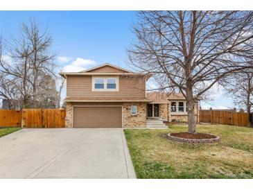 Charming two-story home with a well-maintained lawn and a two car garage at 7604 S Lamar Ct, Littleton, CO 80128