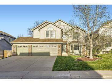 Charming two-story home with a three car garage and manicured front lawn at 10984 Alcott Dr, Denver, CO 80234
