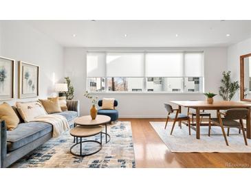 Bright living room with hardwood floors, modern furnishings, and large windows providing ample natural light at 2640 Central Ct # 204, Denver, CO 80211