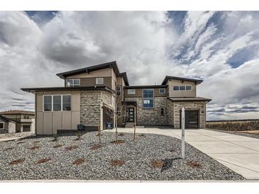 Stunning two-story home with stone accents, modern design, and a well-manicured front yard at 5926 Hickory Oaks Trl, Castle Rock, CO 80104