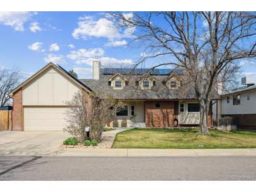 Charming two-story home featuring a well-manicured lawn, brick accents and solar panels on the roof at 10622 Van Gordon Way, Broomfield, CO 80021