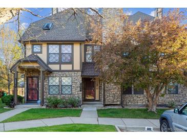 Charming townhome featuring a stone facade and mature landscaping at 18508 E Whitaker Cir # D, Aurora, CO 80015