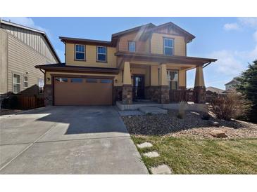 Charming two-story home with a covered front porch and attached two-car garage at 8632 Yule St, Arvada, CO 80007