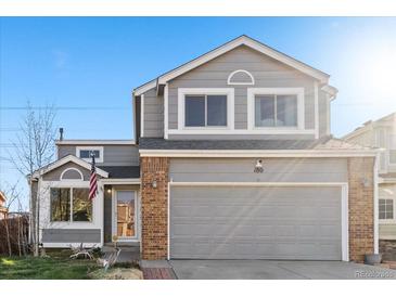 Charming two-story home featuring gray siding, brick accents, and a two-car garage at 180 S Carlton St, Castle Rock, CO 80104